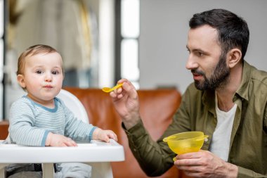 Babası bir yaşındaki oğlunu kaşıkla besliyor..