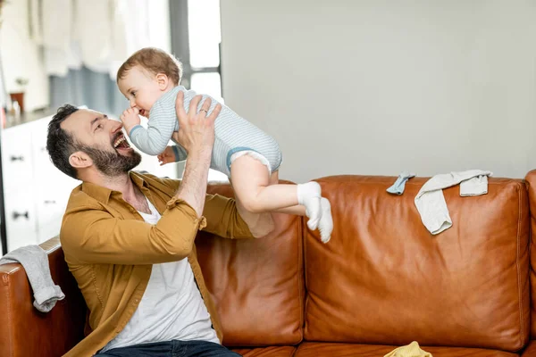 Otec středního věku nosí a hraje si s novorozencem — Stock fotografie
