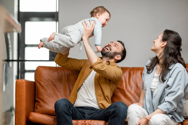 Šťastný otec, matka a malý syn si hrají na gauči v obýváku. Péče o děti a rodičovství — Stock fotografie
