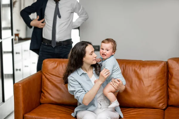 Jovem mãe sentada com o filho recém-nascido no sofá. — Fotografia de Stock