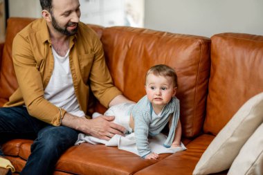 Baba evde tek başına bebek bezi değiştiriyor.