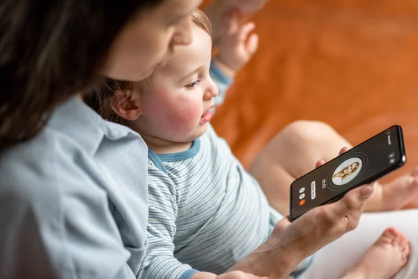 Nuori äiti vastasyntynyt lapsi tekee videopuhelun — kuvapankkivalokuva