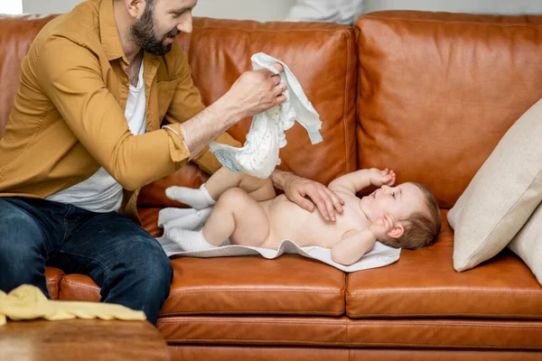 Padre cambiando pañales a su hijo solo en casa — Foto de Stock