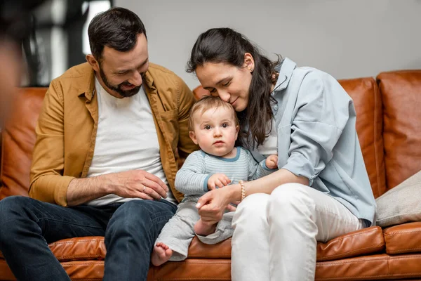 Šťastný otec, matka a malý syn si hrají na gauči v obýváku. Péče o děti a rodičovství — Stock fotografie