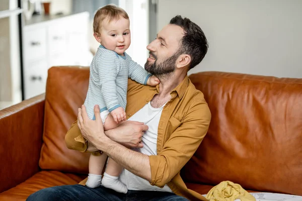 Papá de mediana edad llevando y jugando con el bebé recién nacido — Foto de Stock