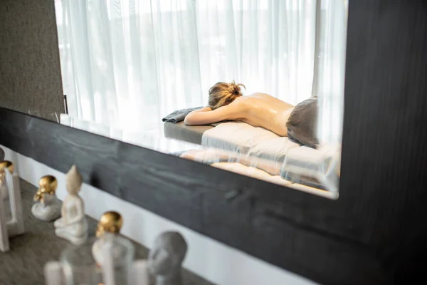Belle femme couchée dans un salon de spa profitant d'un massage du dos profond et de détente. — Photo