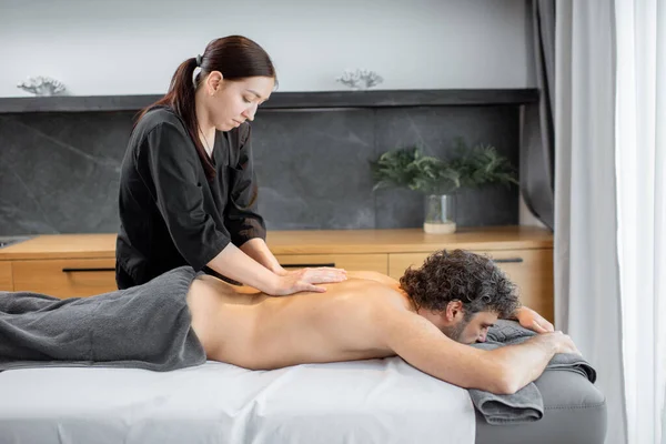Masajista haciendo masaje a cliente masculino. —  Fotos de Stock
