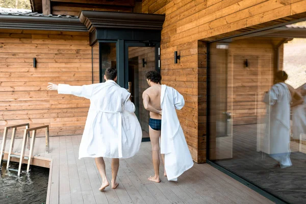 Bedrijf van mannelijke vrienden wandelen op het terras in spa complex — Stockfoto