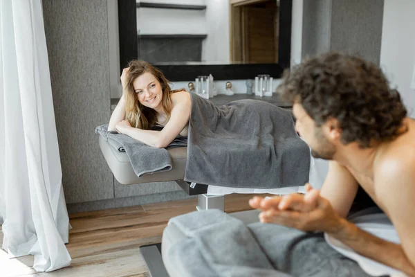 Hermosa pareja tumbada en un salón de spa disfrutando de recibir masaje de espalda profunda y relajación. — Foto de Stock