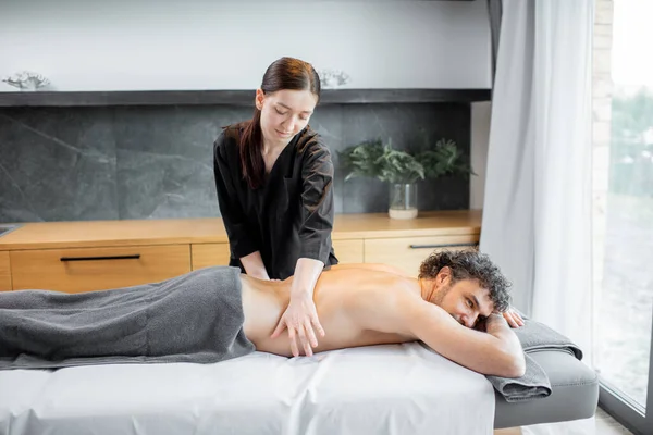 Masseur féminin faisant le massage au client masculin. — Photo