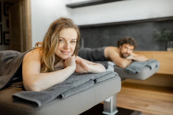 Vackra par som ligger i en spasalong njuter av att få djup ryggmassage och avkoppling. — Stockfoto