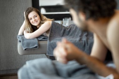 Spa salonunda uzanmış güzel bir çift sırt masajı ve dinlenmenin tadını çıkarıyor..
