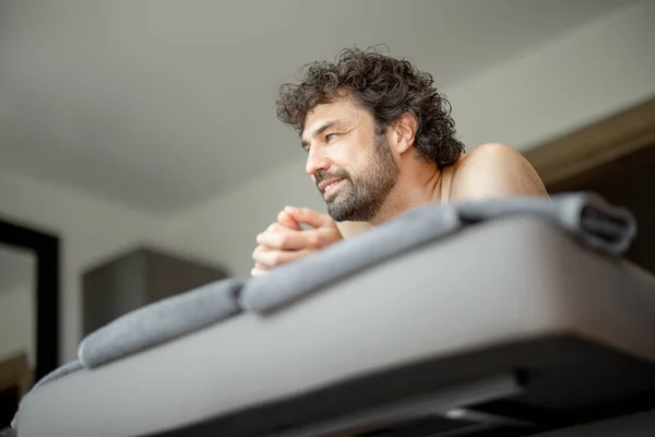 Schöner Mann liegt im Wellness-Salon und wartet auf Rückenmassage — Stockfoto