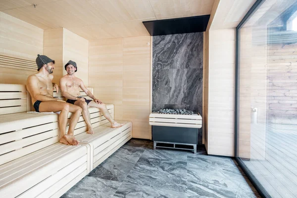 Amis masculins allongés sur un banc en bois dans le sauna — Photo