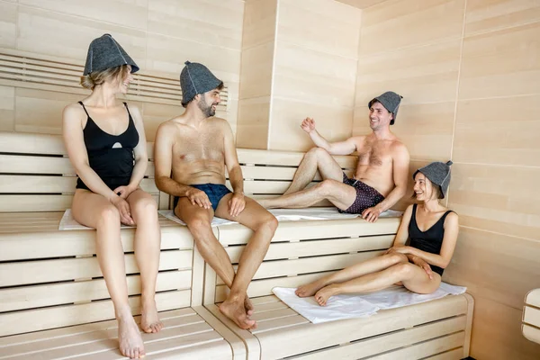 Companhia de amigos deitados no banco de madeira coberto com feno — Fotografia de Stock