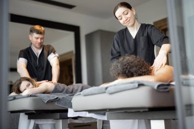 Spa salonunda uzanmış güzel bir çift sırt masajı ve dinlenmenin tadını çıkarıyor..