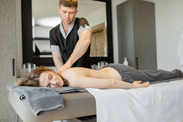 Beautiful woman lying in a spa salon enjoying getting deep back massage and relaxation. — Stock Photo, Image