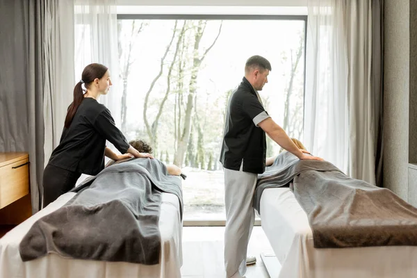 Zwei Masseure bei einer tiefen Rückenmassage für Gäste — Stockfoto