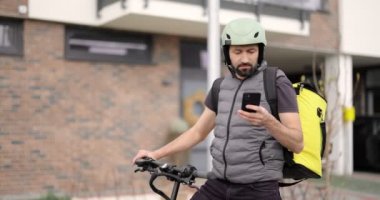 Kurye, elektrikli scooterla mal getiriyor.