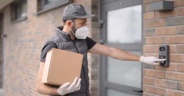 Courier em máscara facial entrega parcelas para casa — Vídeo de Stock