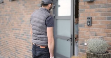 Kurye, bebeği olan genç bir anneye paketi teslim ediyor.