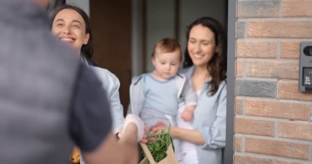 Lesbische Familie mit Baby erhält Auftrag von einem Kurier — Stockvideo