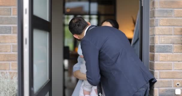 Бізнесмен виходить на роботу, прощаючись зі своєю сім'єю біля дверей — стокове відео