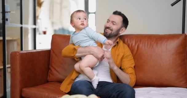 Pai de meia idade carregando e brincando com o bebê recém-nascido — Vídeo de Stock