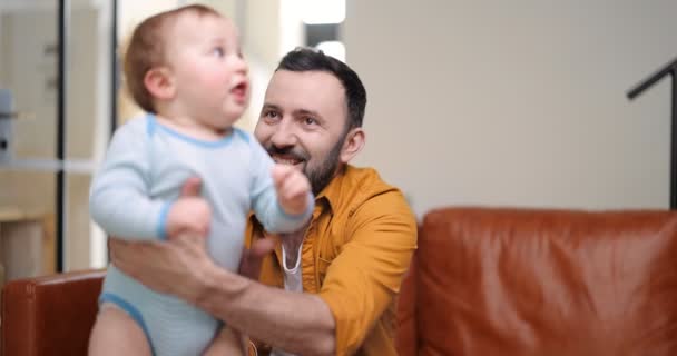 พ่อวัยกลางคนถือและเล่นกับทารกแรกเกิด — วีดีโอสต็อก