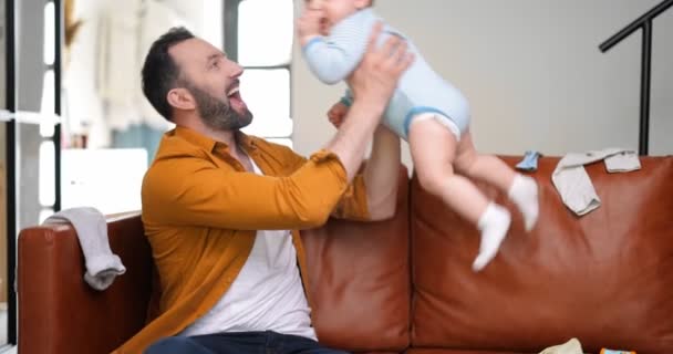 Tata w średnim wieku nosi i bawi się z noworodkiem — Wideo stockowe