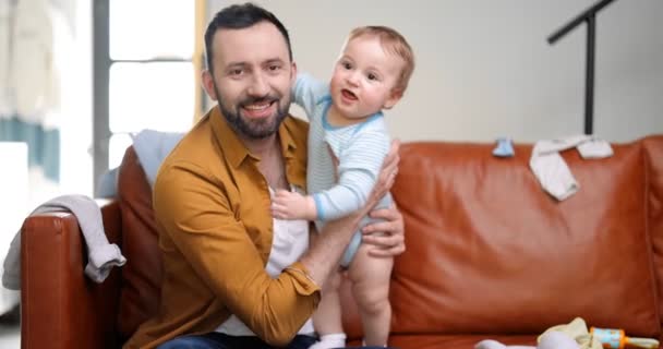 Portrait of a happy father with his young baby boy at home — Stockvideo