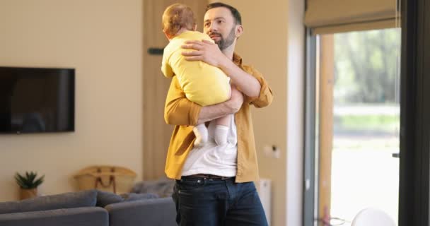 Pai amamentando seu filho bebê e trabalha em casa — Vídeo de Stock