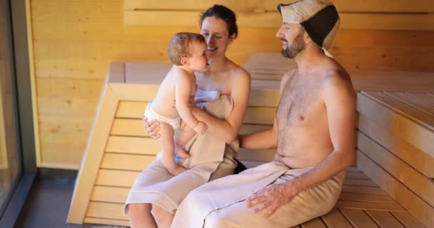 Jonge familie met een kleine jongen in de sauna — Stockvideo