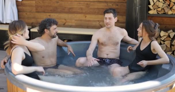 Vrienden hebben plezier baden in de spa buiten — Stockvideo