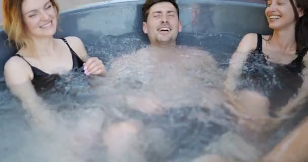Vrienden hebben plezier baden in de spa buiten — Stockvideo