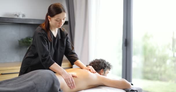 Kvinnlig massör gör massage till manlig klient — Stockvideo