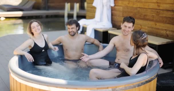 Amigos divirtiéndose bañándose en el spa al aire libre — Vídeos de Stock