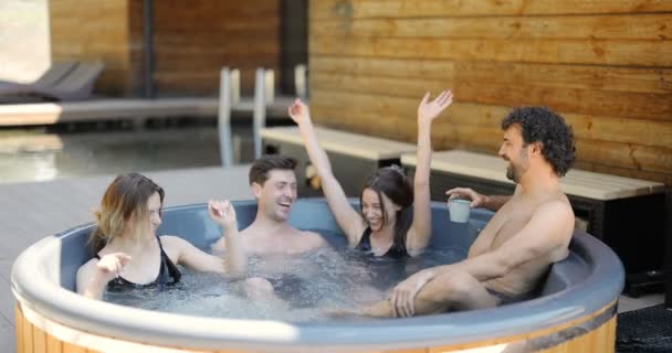 Друзья с удовольствием купаются в спа на открытом воздухе — стоковое видео