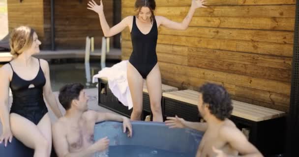 Amigos divirtiéndose bañándose en el spa al aire libre — Vídeos de Stock