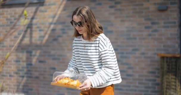 Mulher tomando um café da manhã com croissants e café ao ar livre — Vídeo de Stock