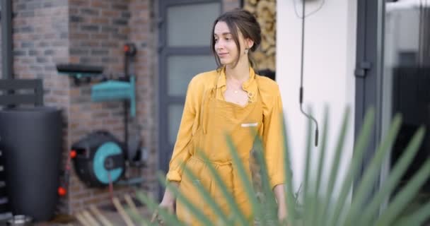 Hausfrau kümmert sich um Pflanzen im Hinterhof — Stockvideo