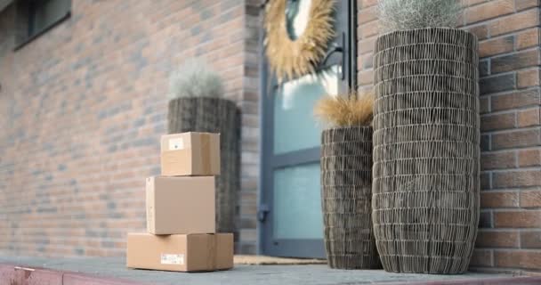 Frau erhält Pakete auf der Veranda ihres Hauses — Stockvideo
