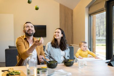 Evde öğle yemeği saatinde bir yaşında bir erkek çocuğu olan mutlu bir aile