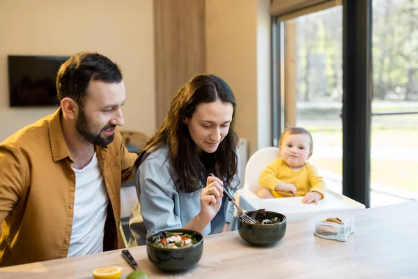 Mladá rodina s jednoletým chlapcem během oběda doma — Stock fotografie