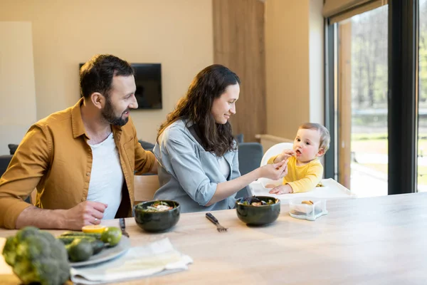 Jeune famille avec un bébé garçon d'un an lors d'un déjeuner à la maison — Photo