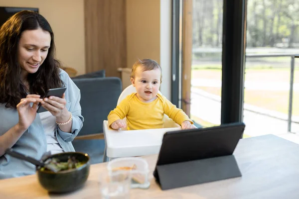 Dítě a rodiče zaneprázdněni v digitální gadgets během oběda doma — Stock fotografie