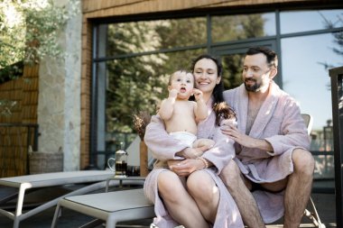 Bir yaşında bir erkek çocuğu olan genç bir aile Spa tatil köyünde dinleniyor.