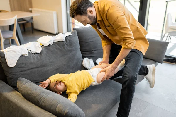 Padre vistiendo a su hijito en casa — Foto de Stock