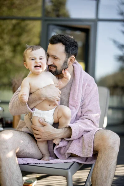 Otec s jednoletým chlapečkem odpočívajícím v lázeňském středisku — Stock fotografie