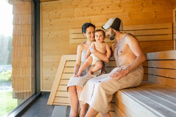 Familia joven con un niño pequeño en sauna —  Fotos de Stock